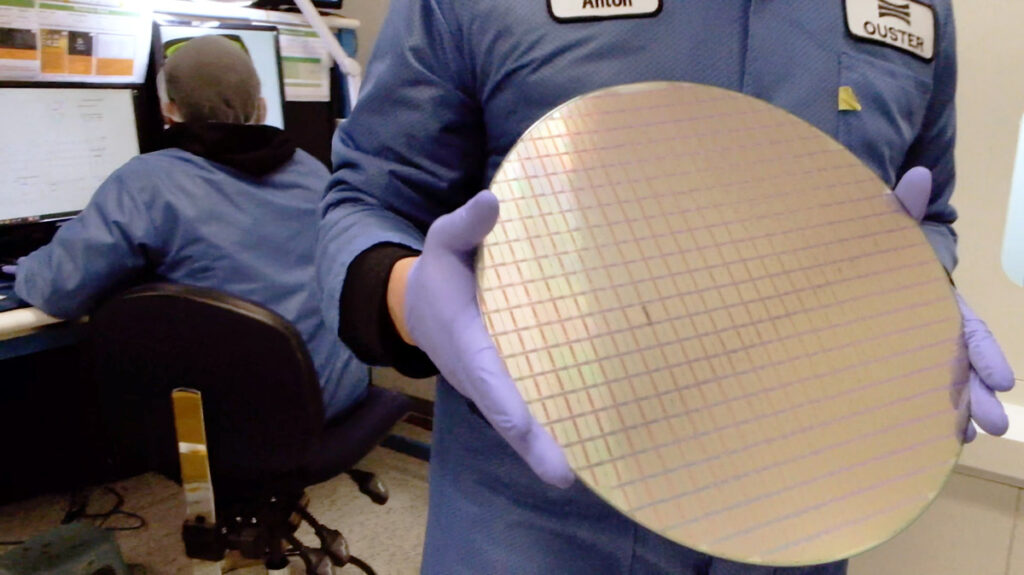 An Ouster employee holds a chip wafer